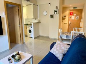 a living room with a blue couch and a kitchen at Apartamento puerto Benicarlo in Benicarló