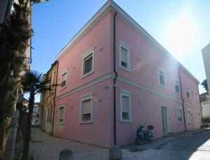 a pink building with a scooter parked next to it at Villa Rosa in Durrës