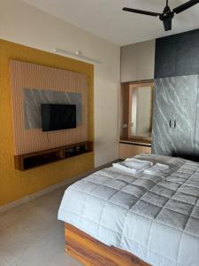 a bedroom with a bed and a flat screen tv at Marvee Luxus Stay in Coimbatore +14 photos