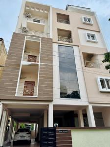 a building with a car parked in front of it at Marvee Luxus Stay in Coimbatore