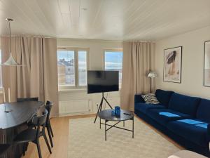a living room with a blue couch and a table at Penthouse Kemi in Kemi