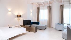 a bedroom with a bed and a couch and a tv at Bellavista Terme Resort & Spa in Montegrotto Terme
