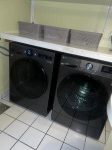 a black washing machine under a counter in a kitchen at My Home Kaldfjorden in Tromsø