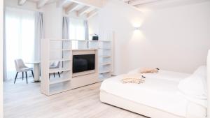 a white living room with a tv and a bed at Bellavista Terme Resort & Spa in Montegrotto Terme