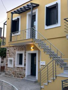 a yellow house with stairs on the side of it at Helios 1 in Chios