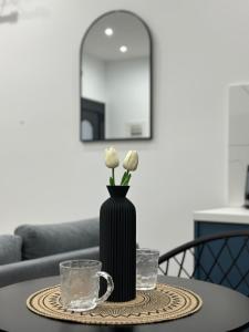 a table with a black vase with white flowers on it at Helios 1 in Chios +4 photos