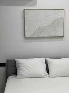 a bed with white pillows and a picture on the wall at Helios 1 in Chios