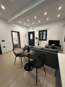 a living room with a couch and a table and chairs at Helios 1 in Chios