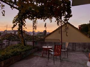a table and two chairs sitting under a tree at Small Hill Guesthouse in Podgorica