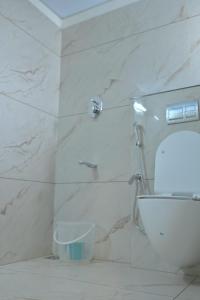 een witte badkamer met douche en toilet bij Hotel Arctic Gold in Cochin