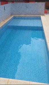 een groot blauw zwembad met blauw water bij Apart Morel in Puerto Iguazú