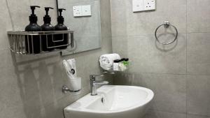 a bathroom with a sink and a mirror and bottles at Opal Heights in Gampaha
