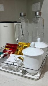 a shelf with a tea pot and two glass bottles at Opal Heights in Gampaha +10 photos