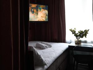 a bedroom with a bed with a television on the wall at Żurawia Mini Apartments by Sofija in Warsaw