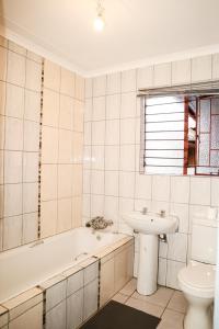 a bathroom with a sink and a tub and a toilet at Lapeng Mogwase Free Parking-Free WIFI in Mogwase