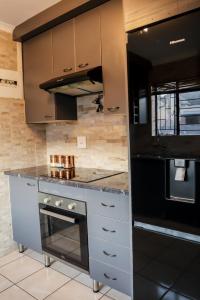 a kitchen with a stove and a black refrigerator at Lapeng Mogwase Free Parking-Free WIFI in Mogwase