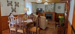 Un comedor con mesa y sillas y chimenea. en Rural Casa Caravaca, Bajo, Campo San Juan, Moratalla, en La Risca