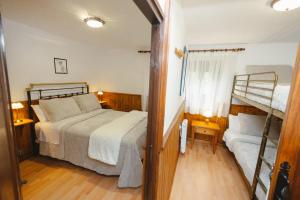 un dormitorio con una cama y dos literas en Rural Casa Caravaca, Bajo, Campo San Juan, Moratalla, en La Risca