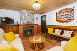 Una sala de estar con sofás y chimenea. en Rural Casa Caravaca, Bajo, Campo San Juan, Moratalla, en La Risca