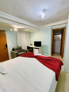 a bedroom with a large white bed and a desk at Pousada Morada Coqueiros in Florianópolis