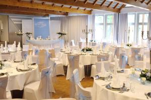 a room filled with tables and chairs with white linens at Kolping-Hotel in Schweinfurt