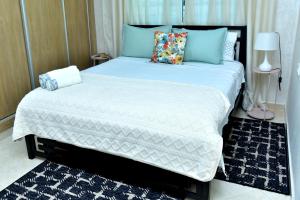 a bedroom with a large white bed with blue pillows at Modern and cozy apartment in the heart of Kenitra in Kenitra