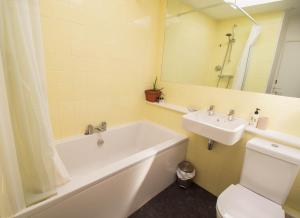 une salle de bain avec une baignoire, des toilettes et un lavabo dans l'établissement Sunset Beach House By Air Premier, à Seaford 14 autres photos