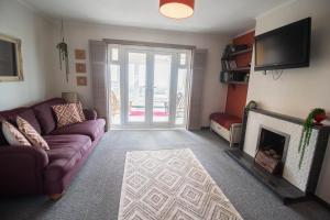 un salon avec un canapé et une cheminée dans l'établissement Sunset Beach House By Air Premier, à Seaford