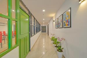 a hallway with green doors and potted plants at FabHotel The Vibe - Nr SR Nagar Metro Station in Hyderabad