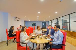 a group of people sitting at a table in a restaurant at FabHotel The Vibe - Nr SR Nagar Metro Station in Hyderabad