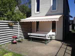 een veranda met een bank en een tafel voor een huis bij Cozy Garden House with a Sauna in Tallinn