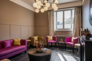 a waiting room with purple couches and chairs at Boutique Hotel KARL in Lucerne +75 photos