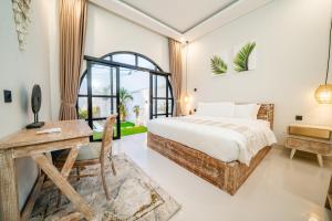 a bedroom with a bed and a desk and a window at Paica House Nusadua in Nusa Dua +6 photos