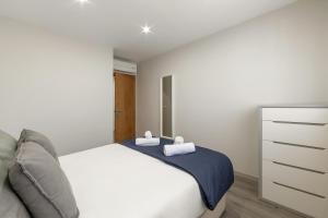 a bedroom with a white bed with two towels on it at Casa Azul in Ferrel