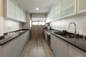 a kitchen with white cabinets and a wooden floor at Casa Azul in Ferrel