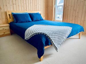 een slaapkamer met een bed met blauwe lakens en een raam bij Cozy Garden House with a Sauna in Tallinn