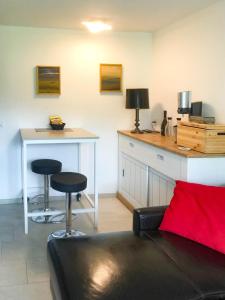 a living room with a couch and a table with two stools at Ferienwohnung Stoos in Stoos
