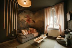 una sala de estar con un sofá y una mesa en Bliss insolite Jacuzzi privée 5 min centre ville, en Mulhouse