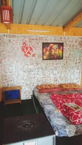 una stanza con un letto nell'angolo di una stanza di Shanti People Huts And Cafe a Kasol
