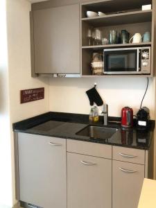 a kitchen with a sink and a microwave at Ferienwohnung Stoos in Stoos