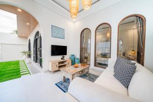 a living room with a couch and a tv at Paica House Nusadua in Nusa Dua