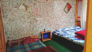 una camera con due letti e un tavolino di Shanti People Huts And Cafe a Kasol