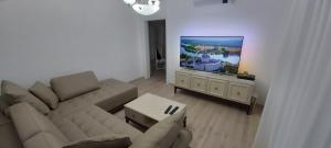 a living room with a couch and a flat screen tv at Apartment Kula Đurišić in Perast