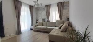 a living room with a couch and some windows at Apartment Kula Đurišić in Perast