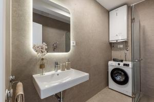 Un baño con lavabo y lavadora. en Seaside Cozy Apartment, en Boreti