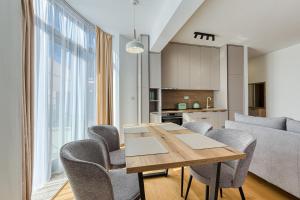 Un comedor con mesa y sillas y una cocina. en Seaside Cozy Apartment, en Boreti