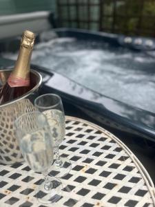 a bottle of champagne and two glasses on a table at Cabin for two Christchurch in Hinton