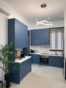 a kitchen with blue cabinets and a potted plant at Helios 2 in Chios +13 photos