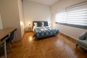 a bedroom with a bed and a desk and a window at Comfy 2BR Flat in Central Athens in Athens