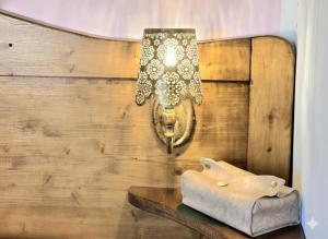 a chandelier hanging on a wooden wall with a table at S'Arrosa de Monti in Villaputzu